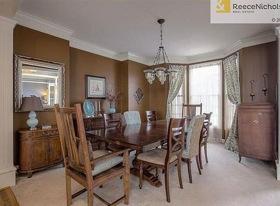 Dining room features pretty bay window and fluted columns.