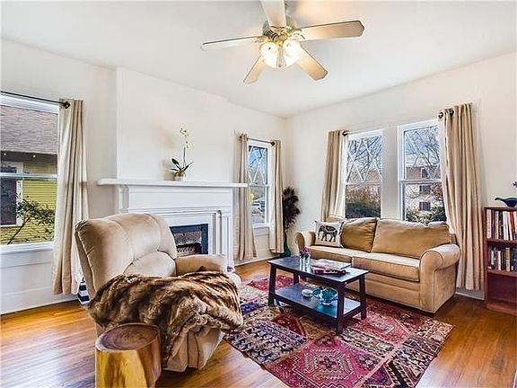 Living area with gorgeous wood floors, bright windows, and f