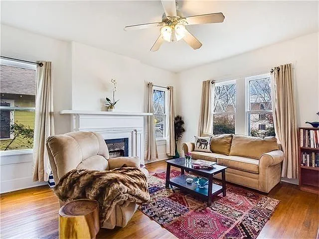 Living area with gorgeous wood floors, bright windows, and f