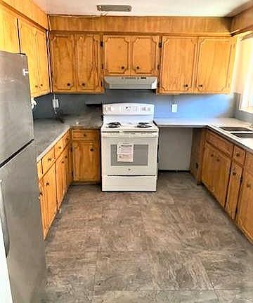 Kitchen with new electric range, newer refrigerator and lots of cabinets