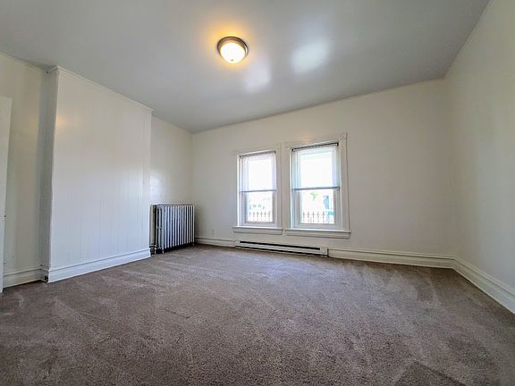Front bedroom from entry to room. Windows face 14th St. Out of frame: closet on left; shelving right