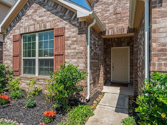 Exterior brick with wood shutters and lush landscaping adds to the curb appeal of this home!