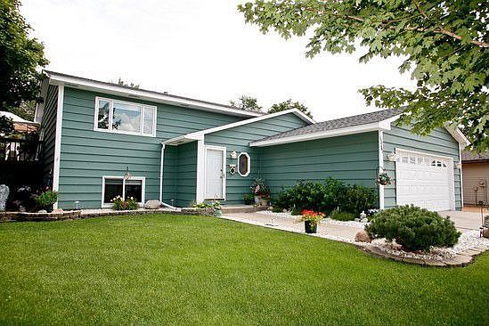 Two shed and a gravel parking pad provide additional storage options.