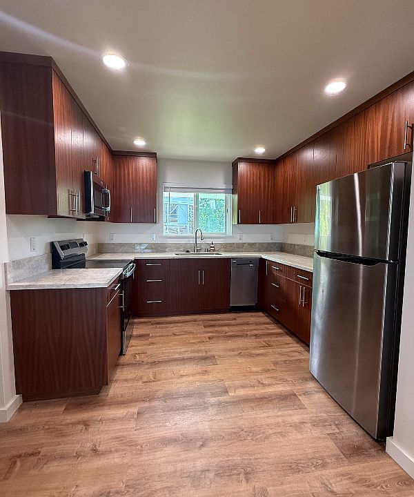 Full kitchen with quartzite counters and new stainless steel appliances, including a dishwasher