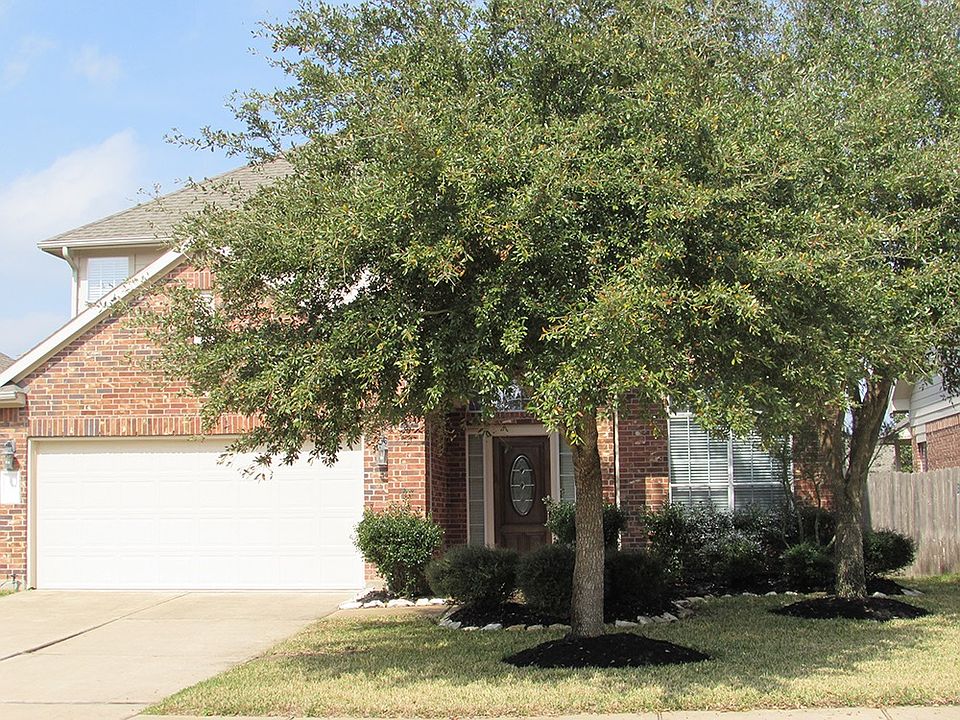 the front of house w/ evergreen trees reducing energy bills!
