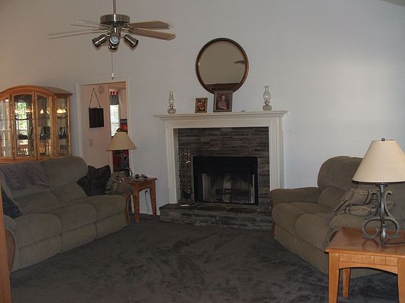 Great room with vaulted ceiling, fan and stacked stone fireplace