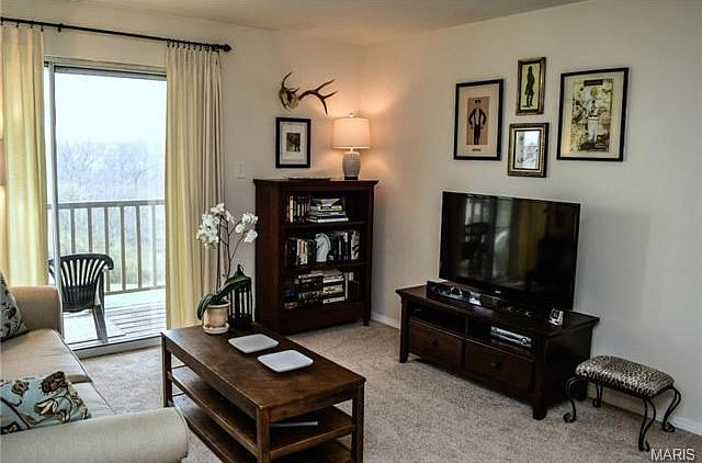 Living room with brand new carpet and sliding doors that lead ou