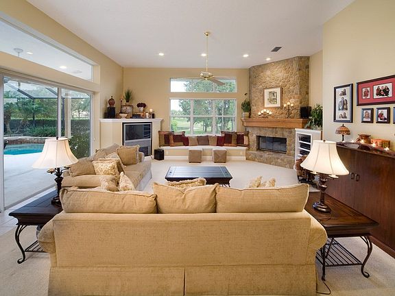 Family room featuring a floor to ceiling rock fireplace with views of pond.