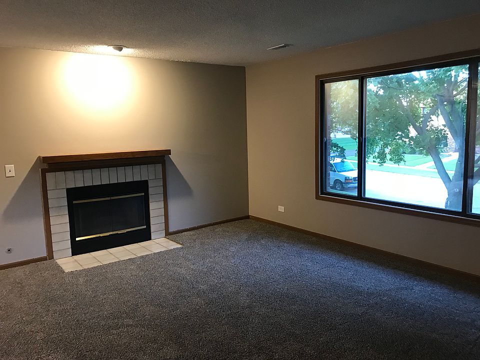 Spacious living room featuring cozy fireplace and large picture window with natural light
