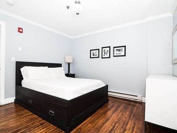 Spacious Master Bedroom with hardwood floors, crown + base molding, and two spacious closets