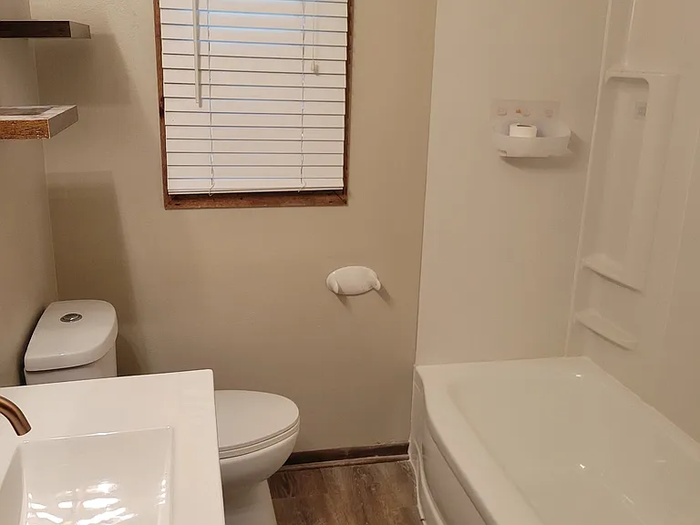main floor full bathroom with shower over tub & new vanity & LVP flooring
