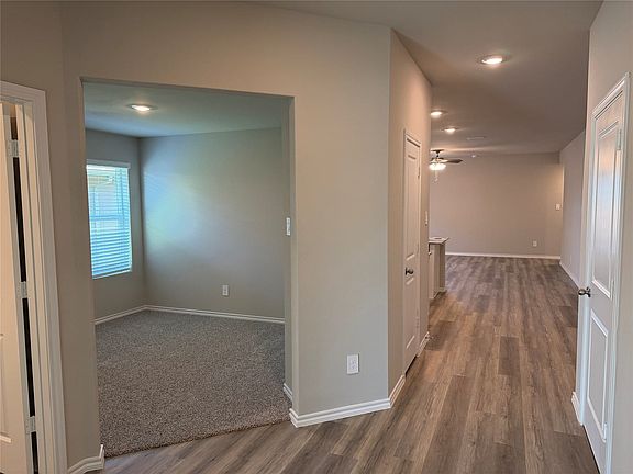 Hallway with wood-finish flooring, recessed lighting, and white baseboards
