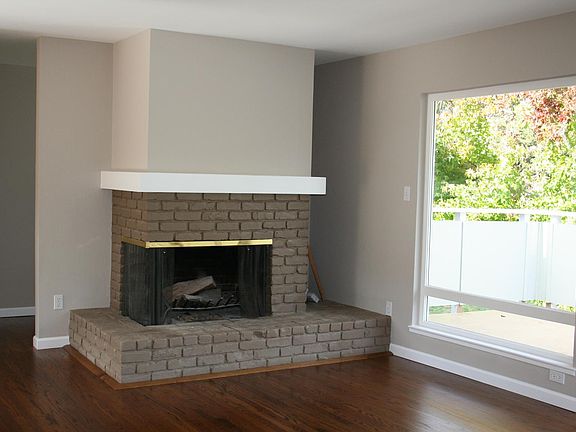 Living room with fireplace, hardwood floors and attached deck.