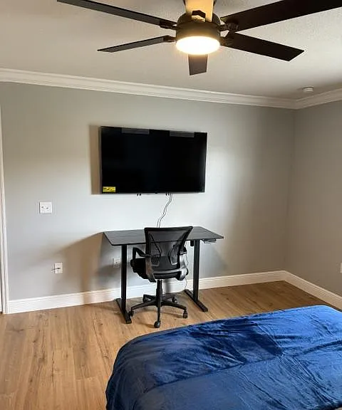 Electric standing desk with ergonomic chair and 55" smart TV