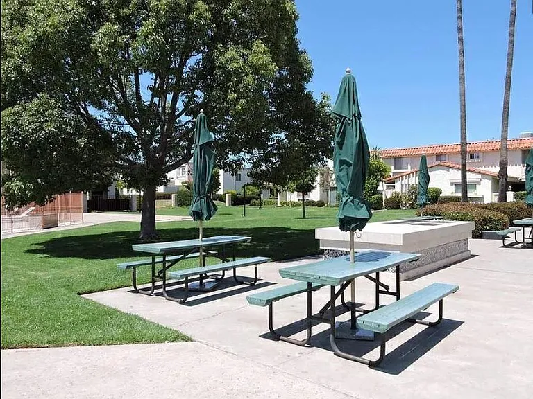 Picnic tables and grill beside pool.