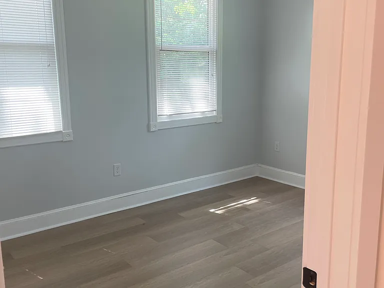 Bedroom on the left from walking in. Heigh ceilings and large windows. Lots of natural light. Totally private with views of open yard on the property. New ceiling fans. Freshly painted. New flooring.