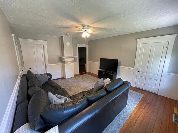 New paint, refinished floors, bathroom door right, entrance door behind cameraman, basement door left, second bedroom left of mantle, den to kitchen right of mantle