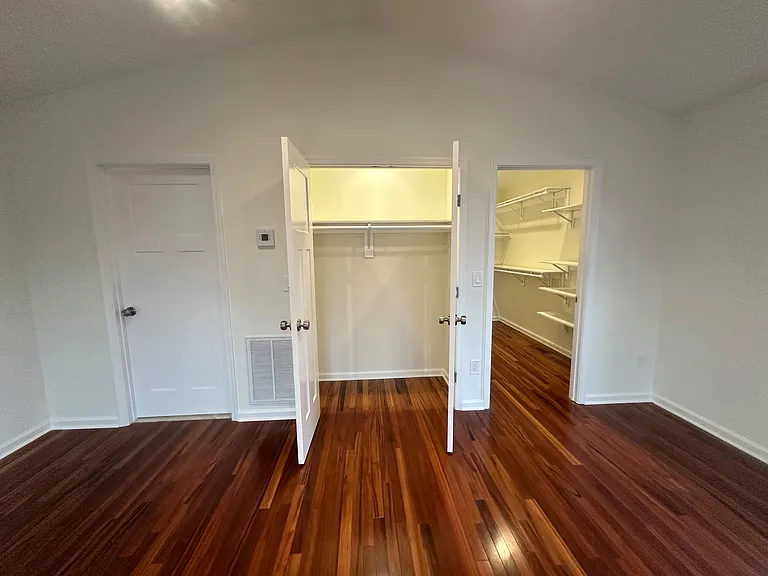 Additional primary suite view to show the two large closets. The closed door leads to the spacious primary bathroom.