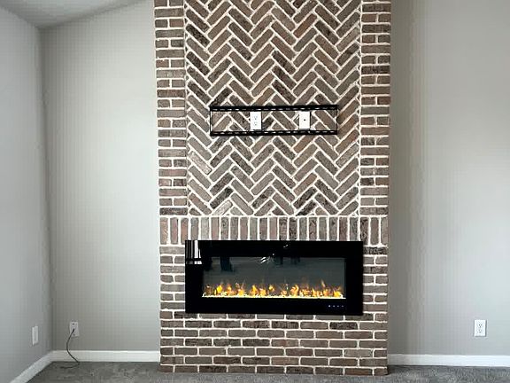 Living room- cozy brick fireplace and comfy carpet