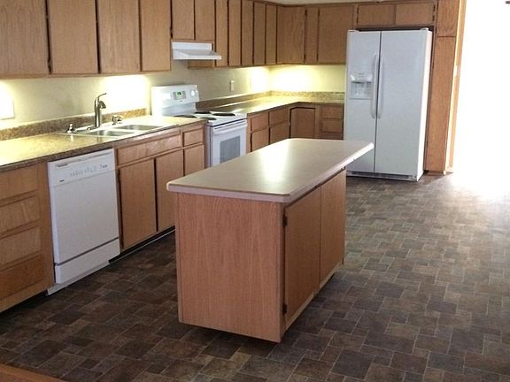 Kitchen with new refrigerator and new floor coverings.