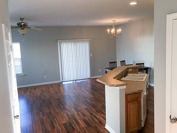 open concept - shades open to outdoor patio, garden, and parking spots