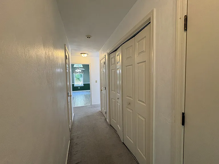 Downstairs hallway (left door leads to half bath, folding doors on right open to the laundry area)