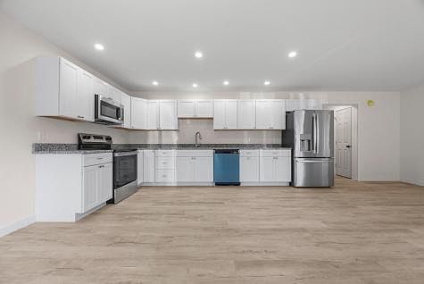 Spacious kitchen with numerous cabinets, SS appliances, pantry space, easy to clean vinyl plank flooring with radiant heat. Large open concept space with kitchen, dining, and LR and patio door to back yard. Large windows for ample sunshine.