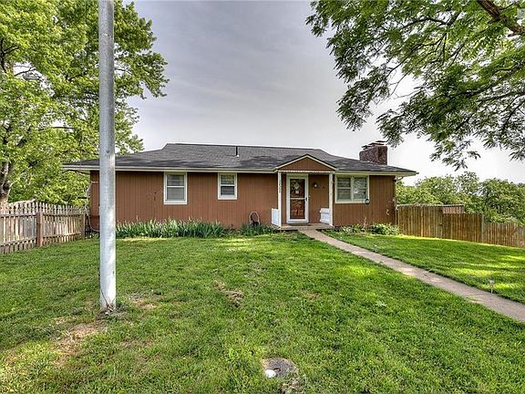 The front of the home.  There is a picket fence around the front yard and a flag pole to hang the American flag.