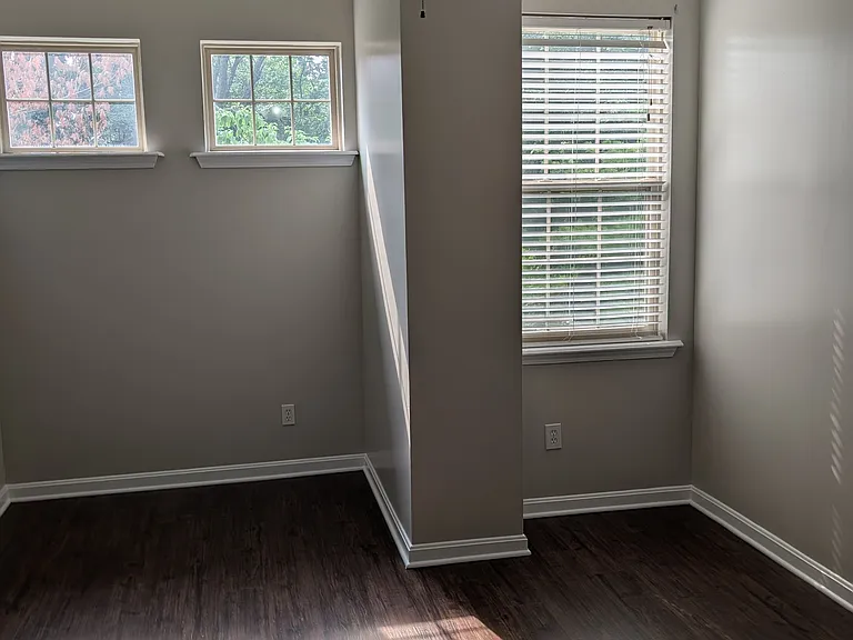 Bright primary bedroom with abundant natural light, blinds, and ceiling fan