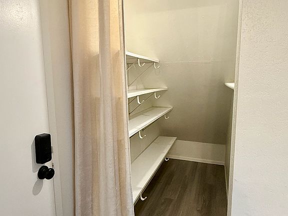 Pantry and storage off kitchen area near entrance to condo