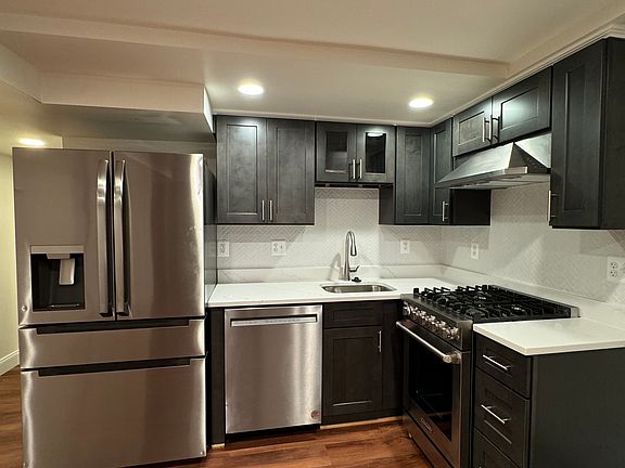 The kitchen has a garbage disposal, a gas cook range, a range hood, a dishwasher, and a refrigerator.