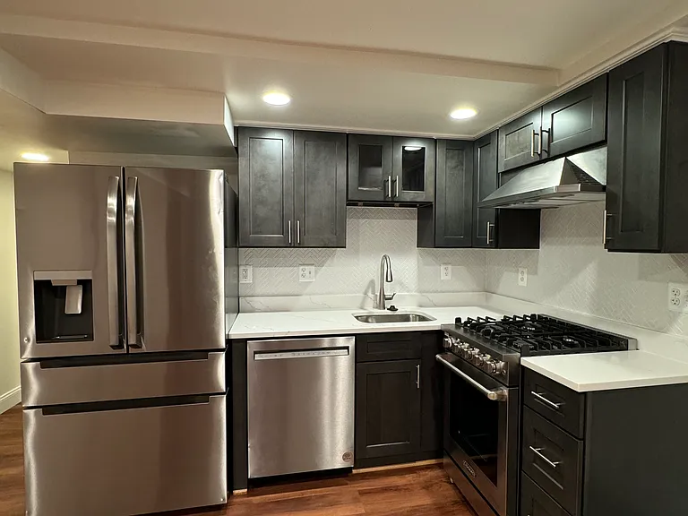 The kitchen has a garbage disposal, a gas cook range, a range hood, a dishwasher, and a refrigerator.