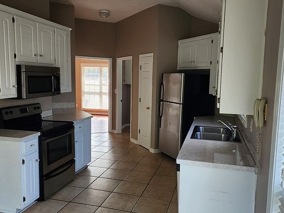 Kitchen area with puck accent light on top and bottom of the cabinets.