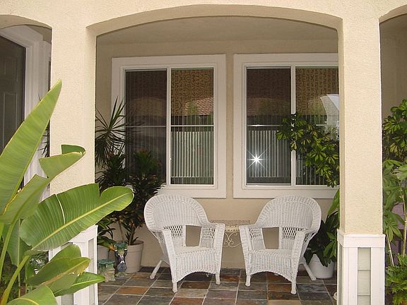 Relaxing front porch welcomes , slate flooring adds to the visual interest.
