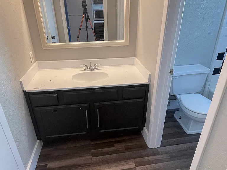 Bathroom vanity area featuring sink, mirror, vanity lighting and attached bathroom.