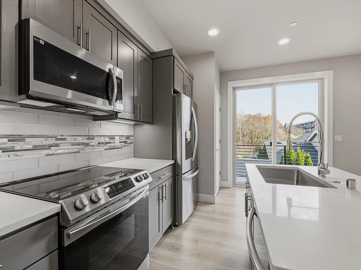 Modern updated kitchen with stainless steel appliances, quartz countertops, tiled backsplash and French door refrigerator - 5020 148th St SW #B1