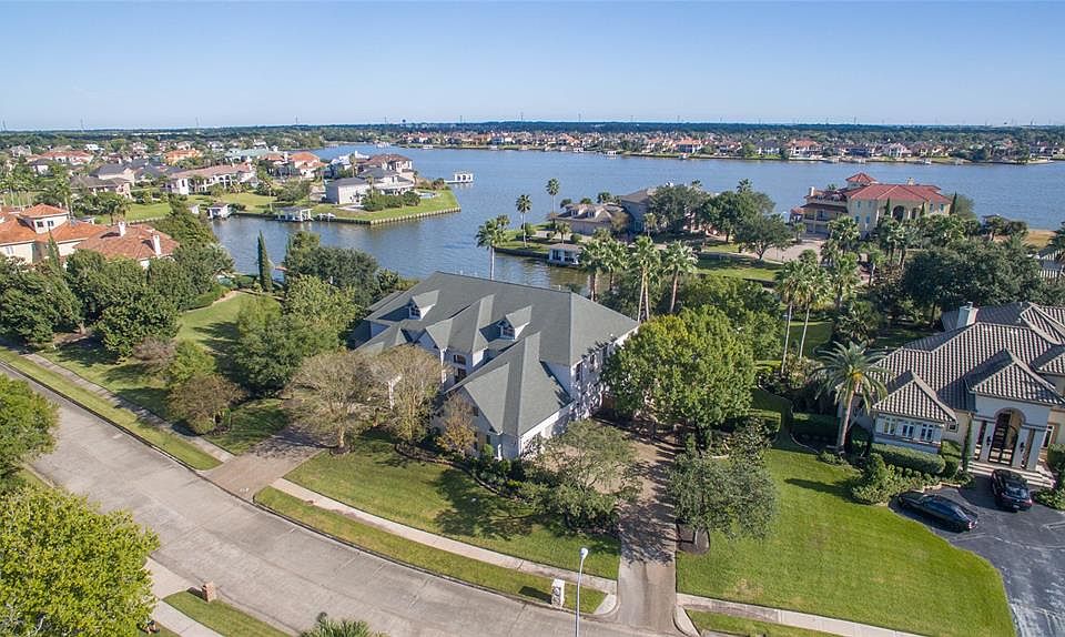 AWESOME VIEW WITH THE LAKE IN THE BACKGROUND ALSO SHOWS THE 2 DRIVEWAYS FOR BOTH THE 3 CAR GARAGE AND SEPARATE PORTE COCHERE.