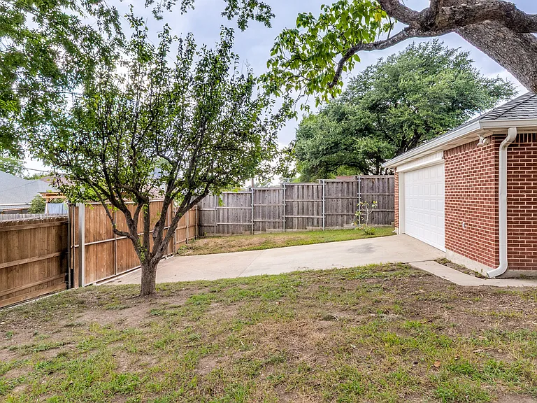 Fenced backyard with two-car garage and sliding gate to the alley.