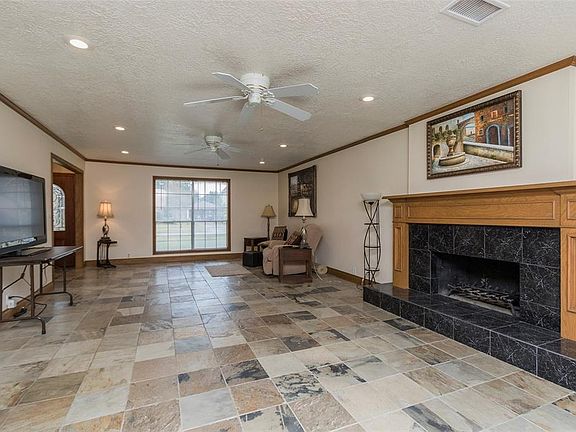 Grand fireplace in the oversize living room with pretty slate flooring that extends throughout the first floor.