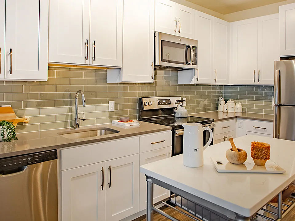 Kitchen featuring modern white cabinetry, stainless steel appliances and movable island