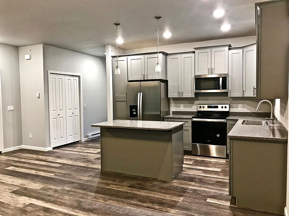 Kitchen in great room with closet and hall leading to bedrooms, two bathrooms, laundry