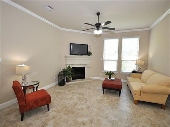 The living room painted, is spacious and bright. features crown molding and ceiling fan.