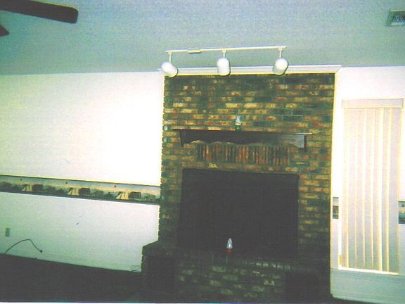 living room has gas log fireplace, clean green carpet