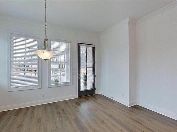 Front door and exterior patio opening into dining room. Hardwood floors throughout