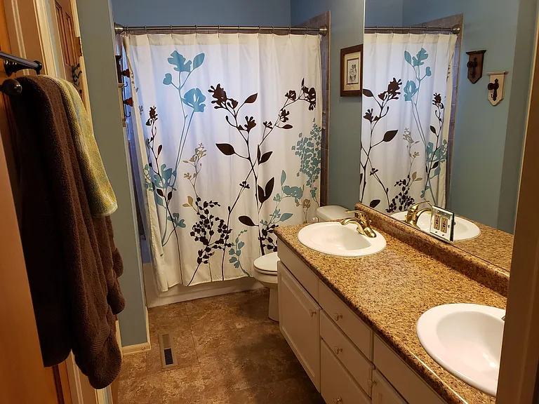Main bathroom with shower/bath combo and two sinks.