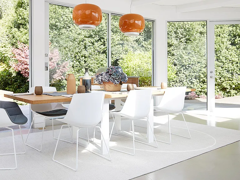 The custom designed quartersawn white oak dining room table comfortably seats eight persons and can even accommodate ten persons. The dining area leads directly outside to the expansive backyard and offers guests seamless indoor outdoor living.