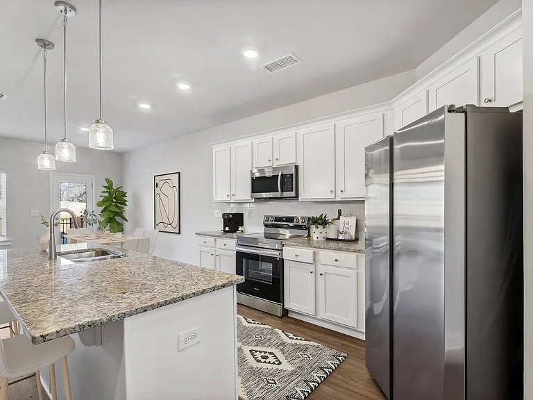 Spacious kitchen with an island, ample storage, stainless steel appliances and view into the backyard.