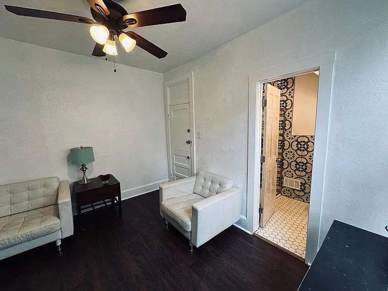 Living room, left entry door, right the bathroom door. Laminate wood floors.
North facing window
