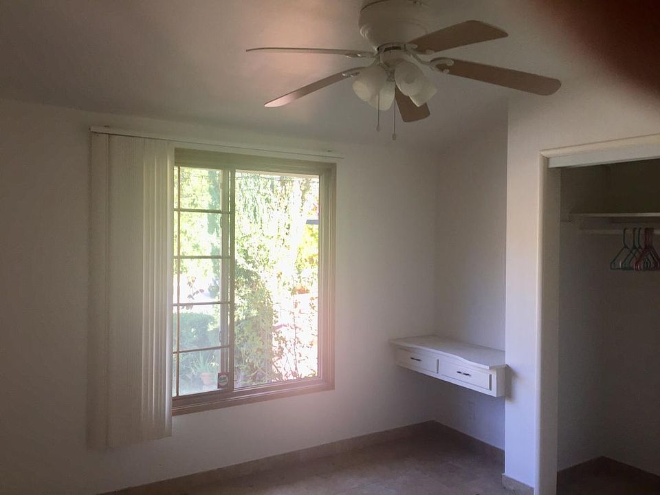 Bedroom with walk-in closet little desk and ceiling fan