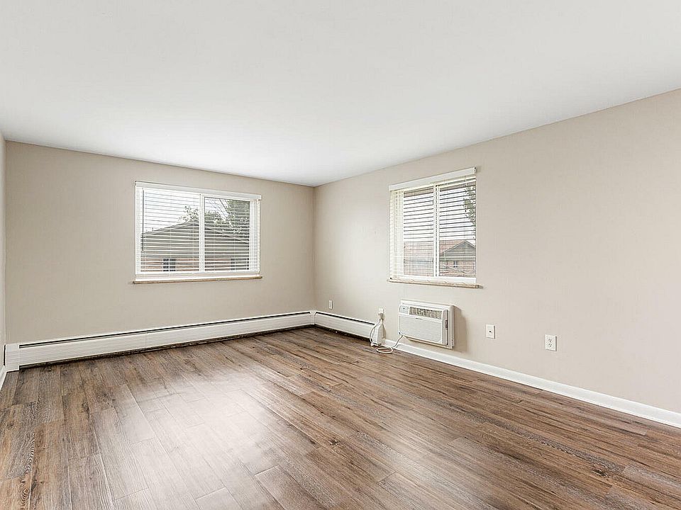Bright spacious room with modern wood flooring and large windows letting in natural light.